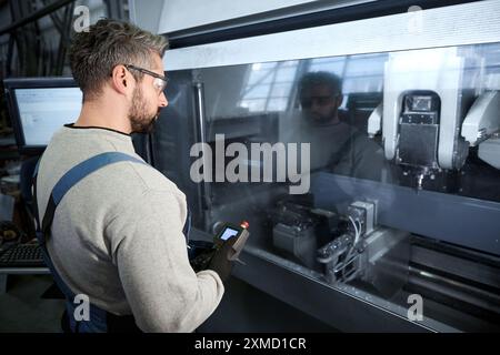 Employee uses a control panel to work on modern equipment Stock Photo