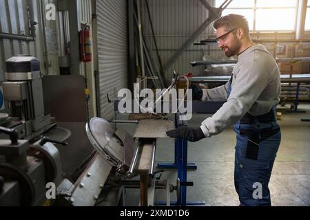 Professional cuts an aluminum profile in a window production Stock Photo