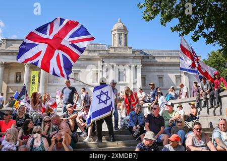 London, UK. 27th July, 2024. Thousands of supporters of Tommy Robinson, real name Stephen Yaxley-Lennon, have marched from the Royal Courts of Justice and are now gathered for a rally in Trafalgar Square, central London. Many have brought Union Jack and St George's Cross flags or are wearing Union Jack colours. Credit: Imageplotter/Alamy Live News Stock Photo