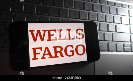 China. 27th July, 2024. In this photo illustration, Wells Fargo logo is displayed on a smartphone with a laptop keyboard background. (Credit Image: © Serene Lee/SOPA Images via ZUMA Press Wire) EDITORIAL USAGE ONLY! Not for Commercial USAGE! Stock Photo