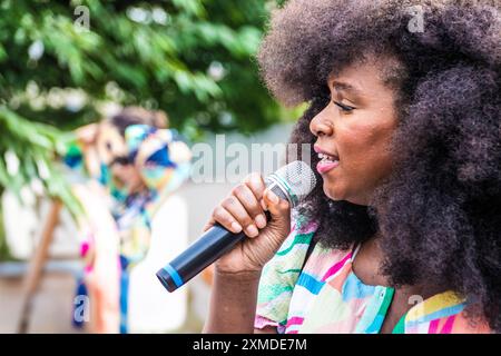 Paris, Île-de-France, 22 June 2024. Close-up of Assa Traoré, French activist and anti-racism campaigner, holding a microphone, with a serious expressi Stock Photo