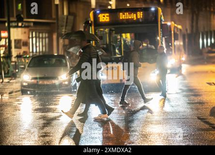 Passers-by at a pedestrian crossing, at the main railway station, rainy weather, city centre, in the evening, Essen, North Rhine-Westphalia, Germany Stock Photo