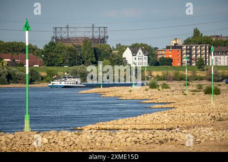 Cargo ship at low water on the Rhine near Duisburg-Homberg, view of Duisburg-Laar, houses on Deichstrasse, gasometer of ArcelorMittal Hochfeld GmbH Stock Photo