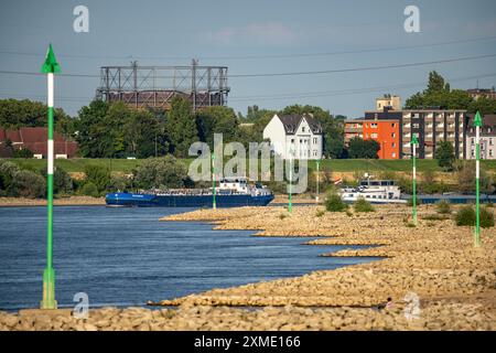 Cargo ship at low water on the Rhine near Duisburg-Homberg, view of Duisburg-Laar, houses on Deichstrasse, gasometer of ArcelorMittal Hochfeld GmbH Stock Photo