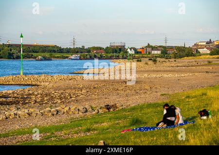 Cargo ship at low water on the Rhine near Duisburg-Homberg, view of Duisburg-Laar, houses on Deichstrasse, gasometer of ArcelorMittal Hochfeld GmbH Stock Photo