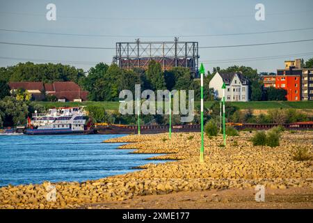 Cargo ship at low water on the Rhine near Duisburg-Homberg, view of Duisburg-Laar, houses on Deichstrasse, gasometer of ArcelorMittal Hochfeld GmbH Stock Photo