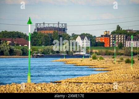 Cargo ship at low water on the Rhine near Duisburg-Homberg, view of Duisburg-Laar, houses on Deichstrasse, gasometer of ArcelorMittal Hochfeld GmbH Stock Photo