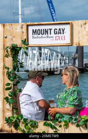 older middle-aged couple embracing and talking on the seafront at cowes during the annual cowes week sailing and yachting regatta on the isle of wight Stock Photo