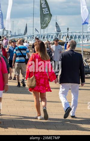 well dressed middle aged coule walking along the promenade at the annual cowes week regatta on the isle of wight on their way to an event Stock Photo