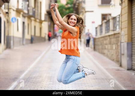 Happy woman jumping in the street Stock Photo