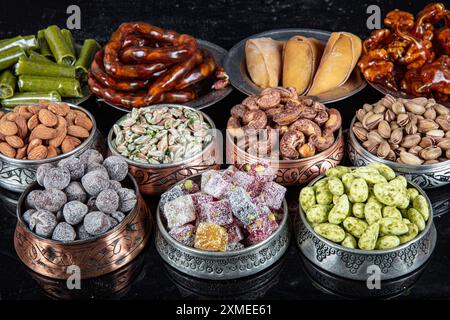 Various nuts in copper bowls top view. Selection of walnuts, cashews, almonds, almond candy, Turkish lukum, hazelnuts and pistachios mix. Healthy fitn Stock Photo