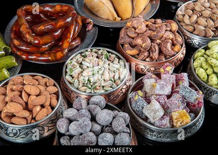 Various nuts in copper bowls top view. Selection of walnuts, cashews, almonds, almond candy, Turkish lukum, hazelnuts and pistachios mix. Healthy fitn Stock Photo