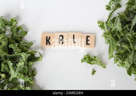 Letter tiles on white background with kale leaves Stock Photo