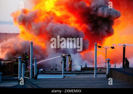 Firefighters extinguish burning industrial building in the city. Stock Photo