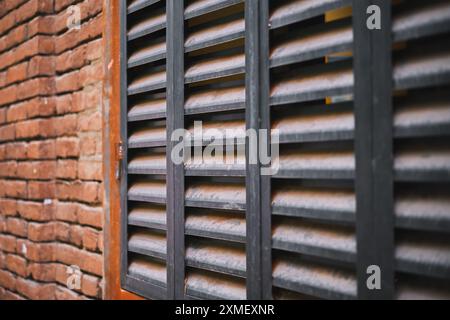 Poster with metal blinds on the wall of an old brick house, poster for advertising concept about construction and reconstruction of houses Stock Photo