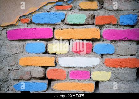 Painted multi-colored bricks on an old house wall, the concept of house reconstruction and creation of art spaces in old industrial areas, an idea for Stock Photo