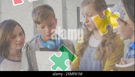 Jigsaw puzzle and human head icon over diverse group of students using laptop at school Stock Photo
