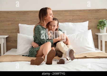 Mother hugging her teenage daughter in bedroom. Family difficulties concept Stock Photo