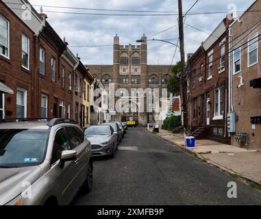 The vacant Thomas Fitzsimons Junior High School stands at the end of a block of row homes along Firth Street in North Philadelphia. Stock Photo