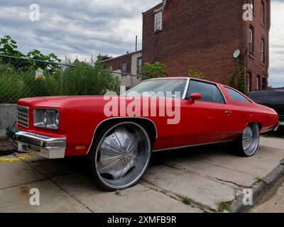 A modified Chevrolet, referred to as a donk, sits parked on the sidewalk in North Philadelphia. Stock Photo