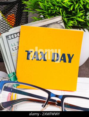 Tax Day Taxation Financial Money Money Concept. Words TAX DAY on a yellow sticker on the table Stock Photo