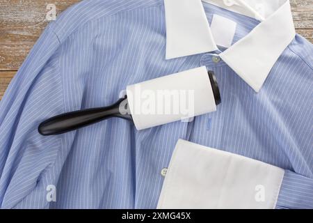A top down view of a dress shirt, featuring a lint roller. Stock Photo