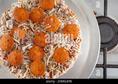A top down view of a dairy-free and gluten-free frozen pizza, resting on a stove top. Stock Photo