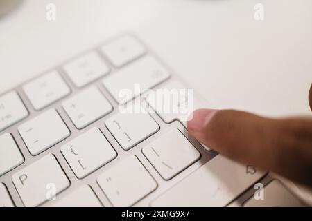 Finger on wireless keyboard enter button. Person's finger pressing submit button Stock Photo