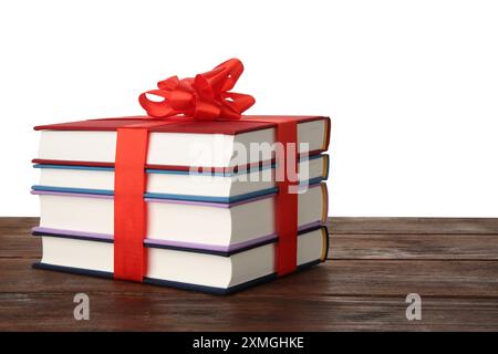 Stack of books with ribbon as gift on wooden table against white background Stock Photo