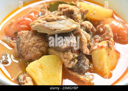 spicy boiled roasted duck meat with pineapple and tomato in coconut milk curry soup on bowl Stock Photo