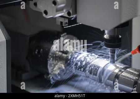 A modern cnc machine produces a piece of metal part using the milling method Stock Photo