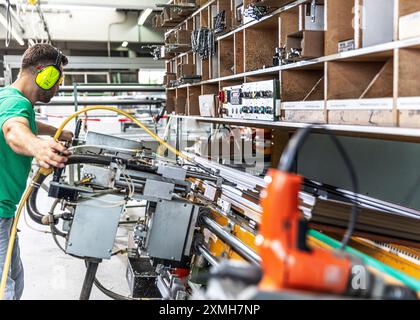 Skilled worker in a window factory, standing in front of a machine Stock Photo