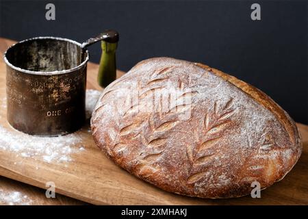 UK. A loaf of freshly baked homemade traditional sourdough bread. the bread is resting on a kitchen worktop whilst it cools Stock Photo