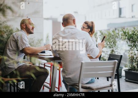 Young business entrepreneurs strategizing and collaborating on a project outdoors Stock Photo