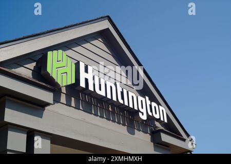 Huntington Bank sign, with logo, on the roof gable of a bank in Michigan Stock Photo