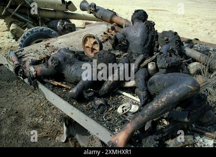 4th March 1991 Incinerated bodies of Iraqi soldiers lie sprawled on the back of a flat-bed truck in the desert. They were attacked by USAF fighter jets about a week before. They were possibly the crew of a towed Soviet 122 mm Howitzer 2A18 (D-30), seen in the background. Stock Photo