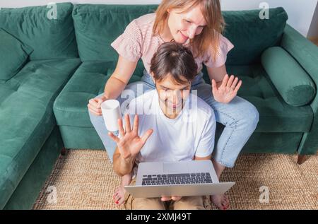 Happy couple waving hands while making online video call with digital tablet. man and  woman doing video call with family from home with copy space. Stock Photo