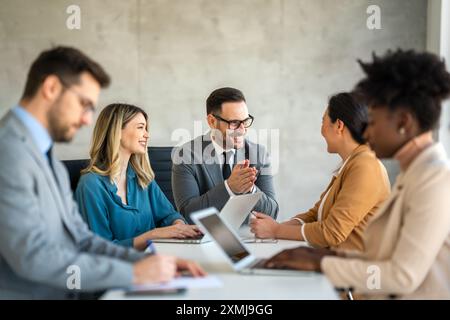 Successful business professionals presenting analytical report, working together in corporate office Stock Photo