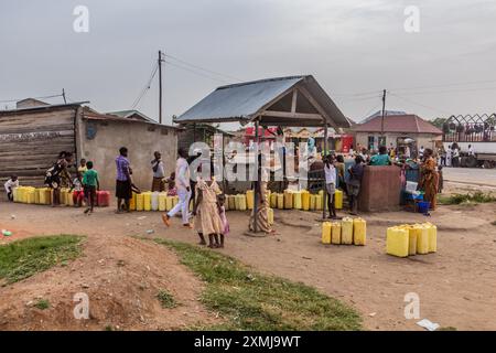 KATUNGURU, UGANDA - MARCH 16, 2020: People wait for water at a village well in Katunguru, Uganda Stock Photo