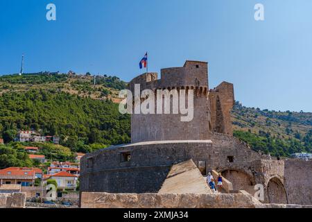 DUBROVNIK, CROATIA - JUNE 29, 2024: Tourists walk around spectacular ancient city walls which encircle Dubrovnik's historic Old City, Stock Photo