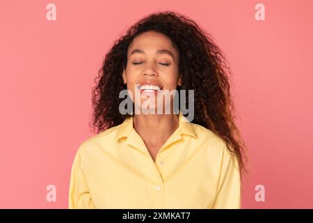 Portrait of Smiling Woman With Curly Hair Against Pink Background Stock Photo