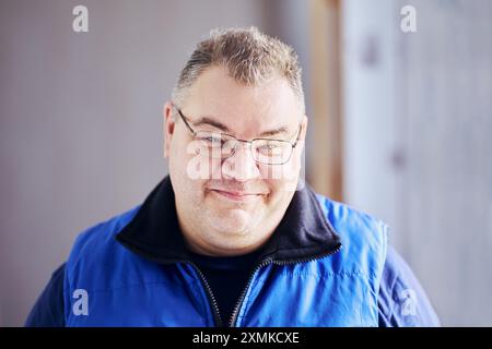 Grinning thick-cheeked European man in her 40s wearing glasses. Stock Photo