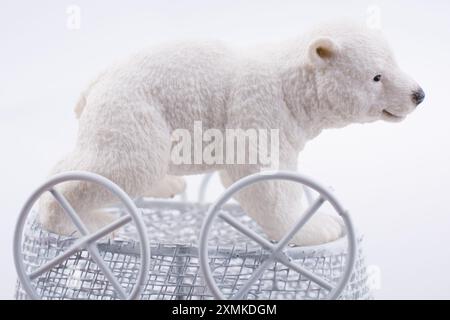 Little  Polar bear figure in a toy  baby carriage  made of metal on Stock Photo