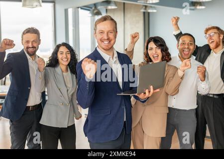 Business Team Celebrating Success With Laptop in Modern Office Stock Photo