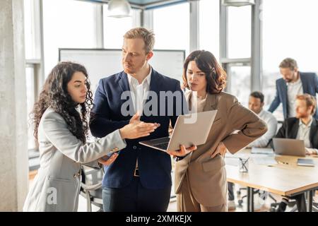 Business Professionals Collaborating on Laptop in Modern Office Stock Photo