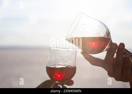 Two people are holding up their wine glasses to toast Stock Photo