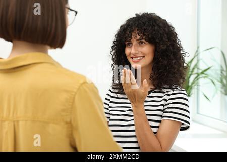 Young women using sign language for communication indoors Stock Photo