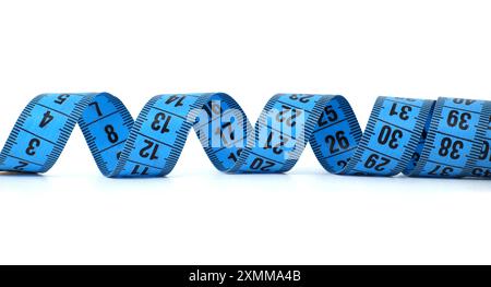 Close-up of a blue measuring tape isolated on a white background, displaying measurements in numbers. Ideal for fitness, sewing, and weight loss conce Stock Photo