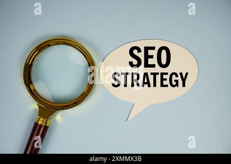 SEO strategy text on bubble speech with magnifying glass top view on blue backgrond Stock Photo