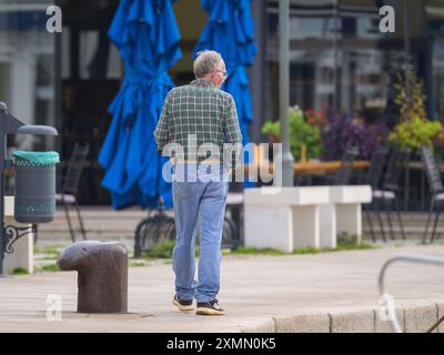Cres, Croatia - October 25, 2022: A middle-aged man walking alone in the city cres on a cloudy day Stock Photo